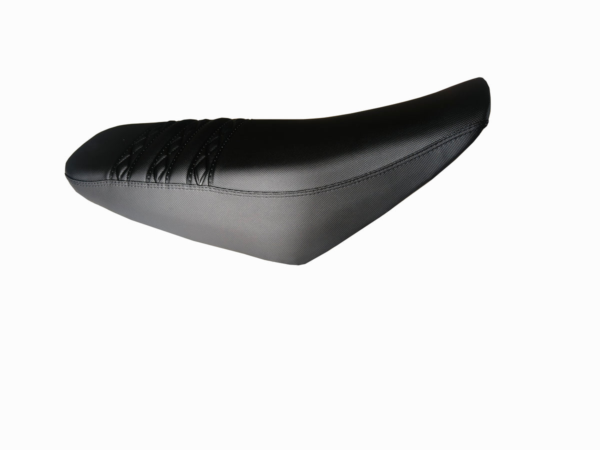 Black dirt bike seat, angled view, smooth side panels and tapered nose