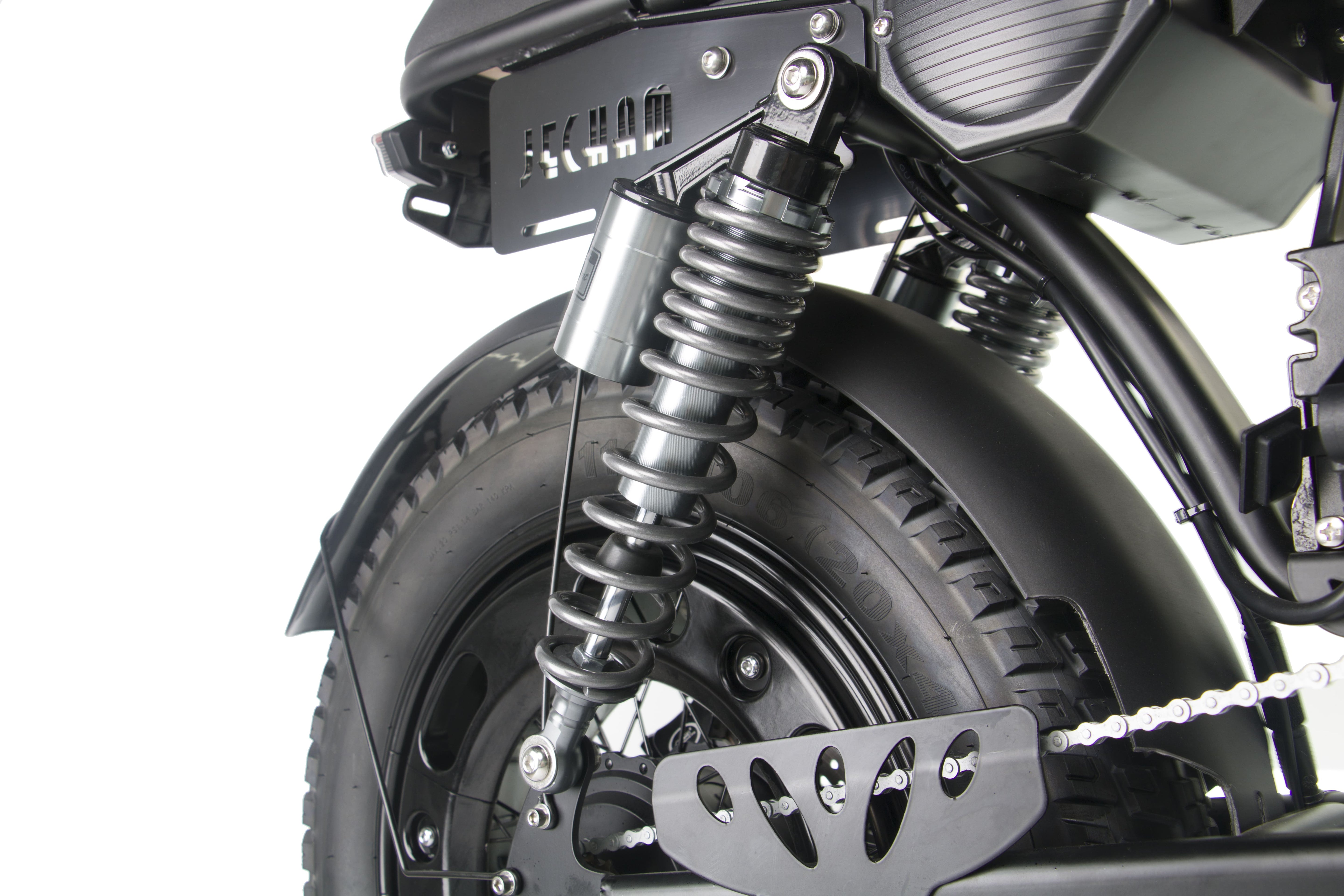 Rear suspension spring and front tire area on a black electric motorcycle.