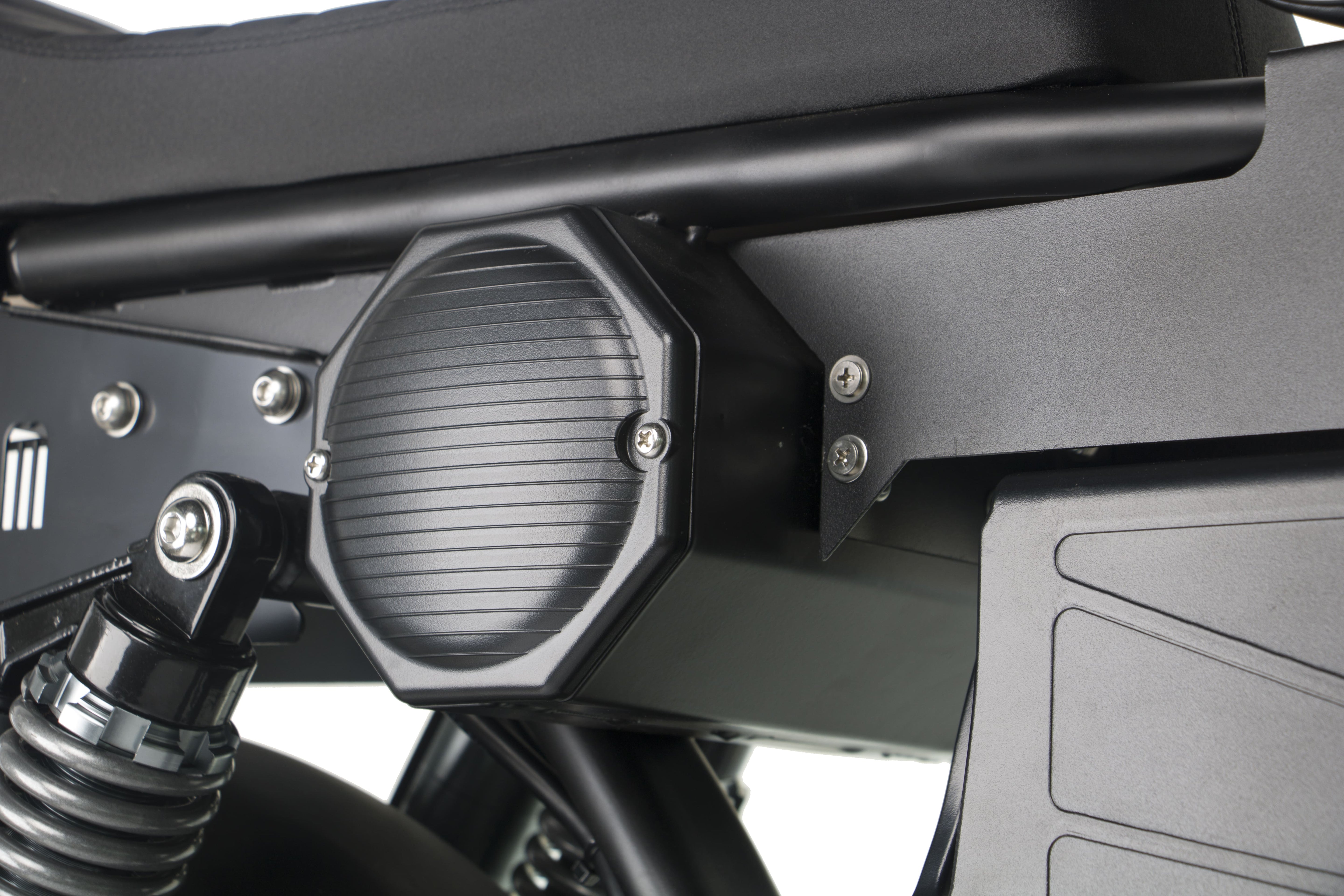 Round side light and black panel on a black electric motorcycle.