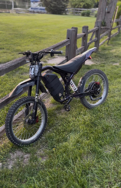 Black electric dirt bike with rear shock suspension and knobby tires