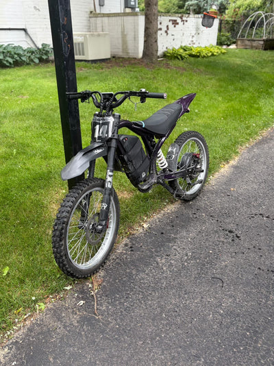 Black electric dirt bike with number plate 11 and knobby tires