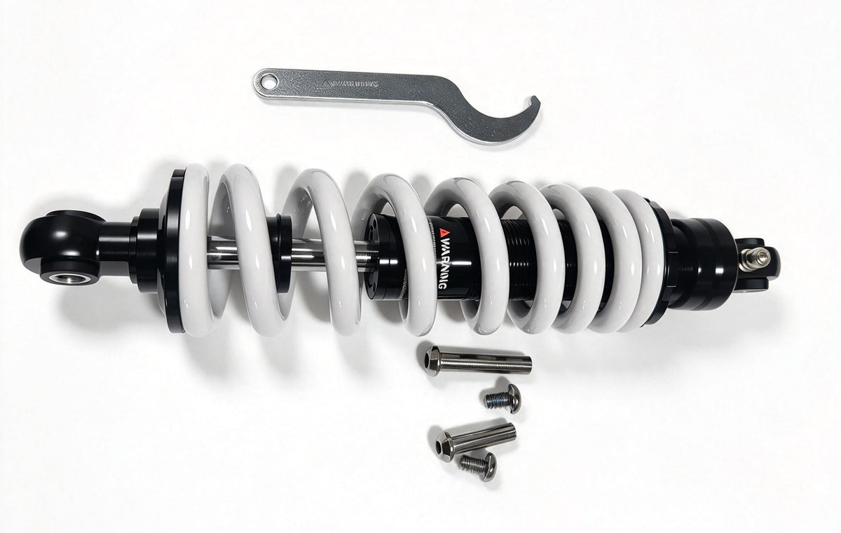 QF200 shock absorber shown horizontally with white spring, wrench and mounting hardware