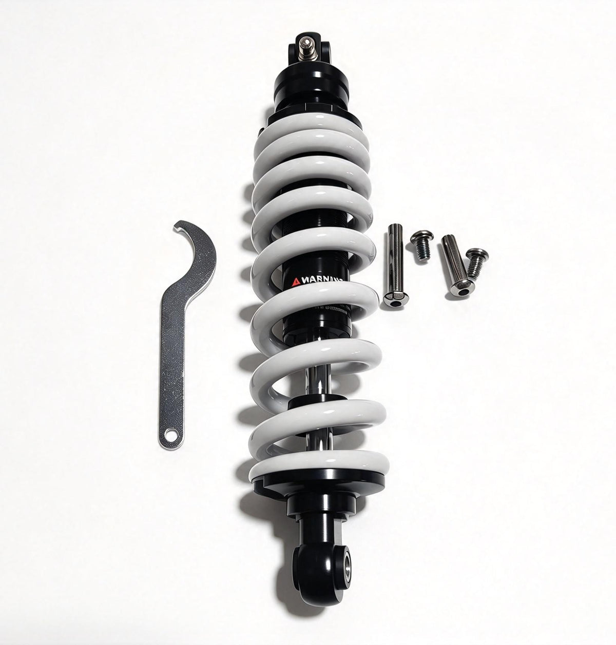 QF200 shock absorber with white coil spring and black body, viewed upright beside wrench and bolts