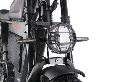 Front headlight housing and fork area on a black electric motorcycle.