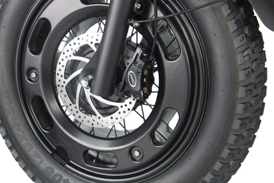 Front wheel and disc brake of a black electric motorcycle with knobby tire tread.
