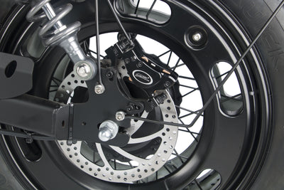 Front wheel rotor and spokes with fork suspension on a black electric motorcycle.