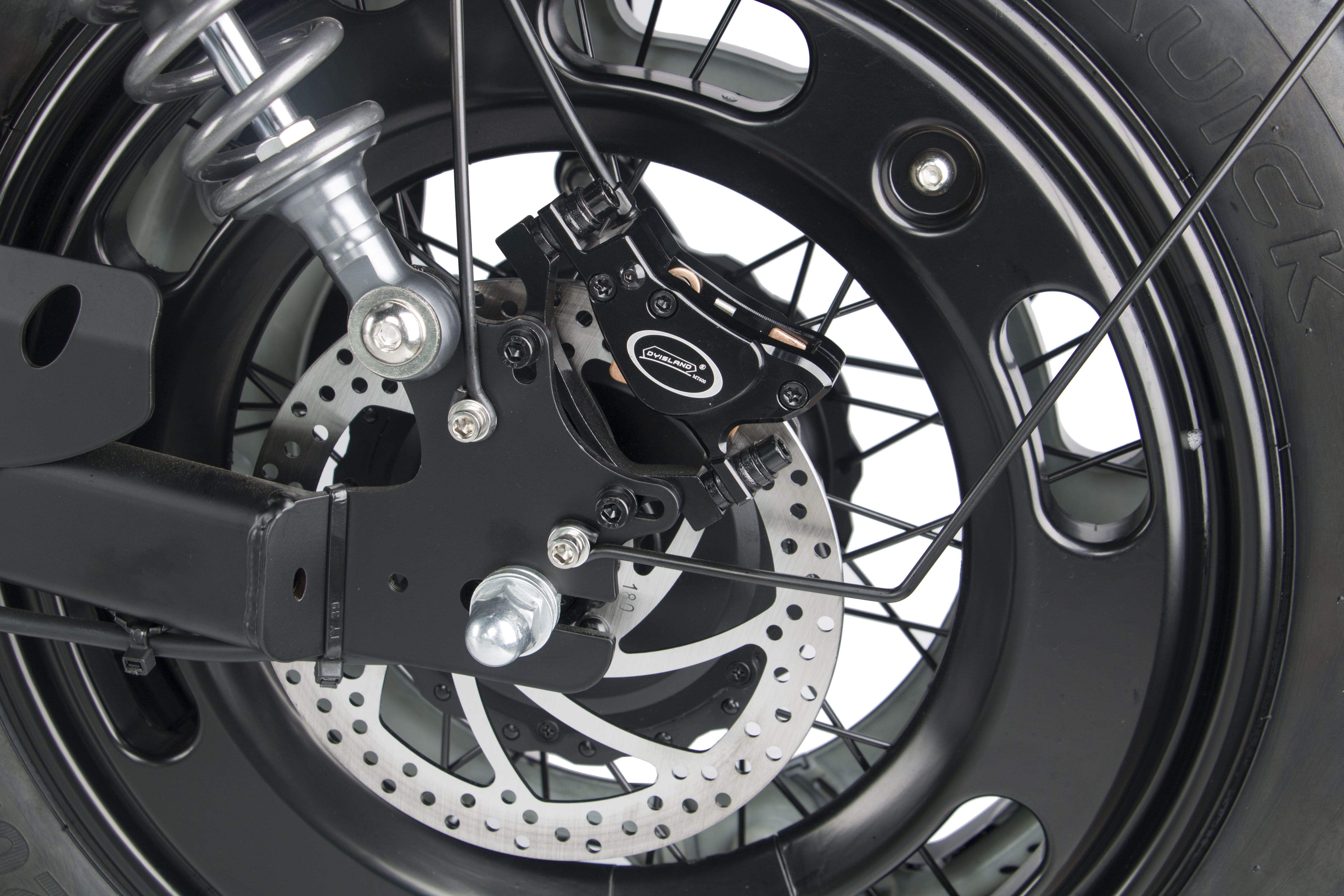 Front wheel rotor and spokes with fork suspension on a black electric motorcycle.